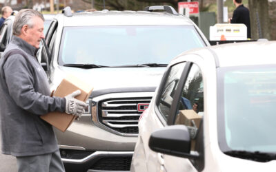 El senador Brewster y sus socios organizan un acto de distribución de alimentos en coche